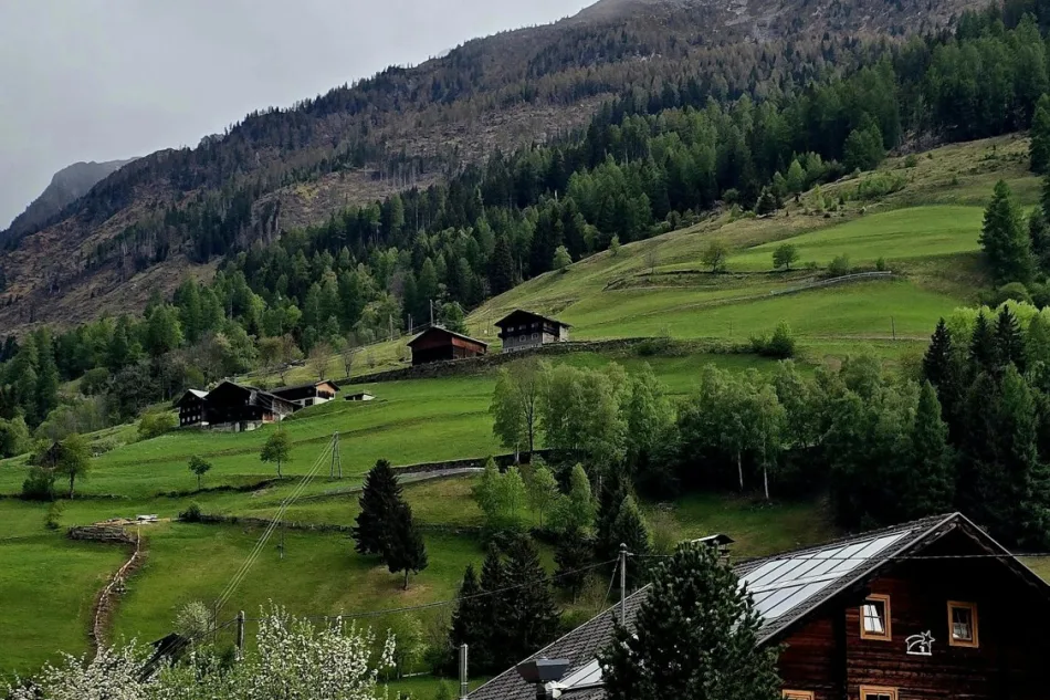 Unsplash Ortschaft mit traditionellen Häusern vor bewaldeten Bergen